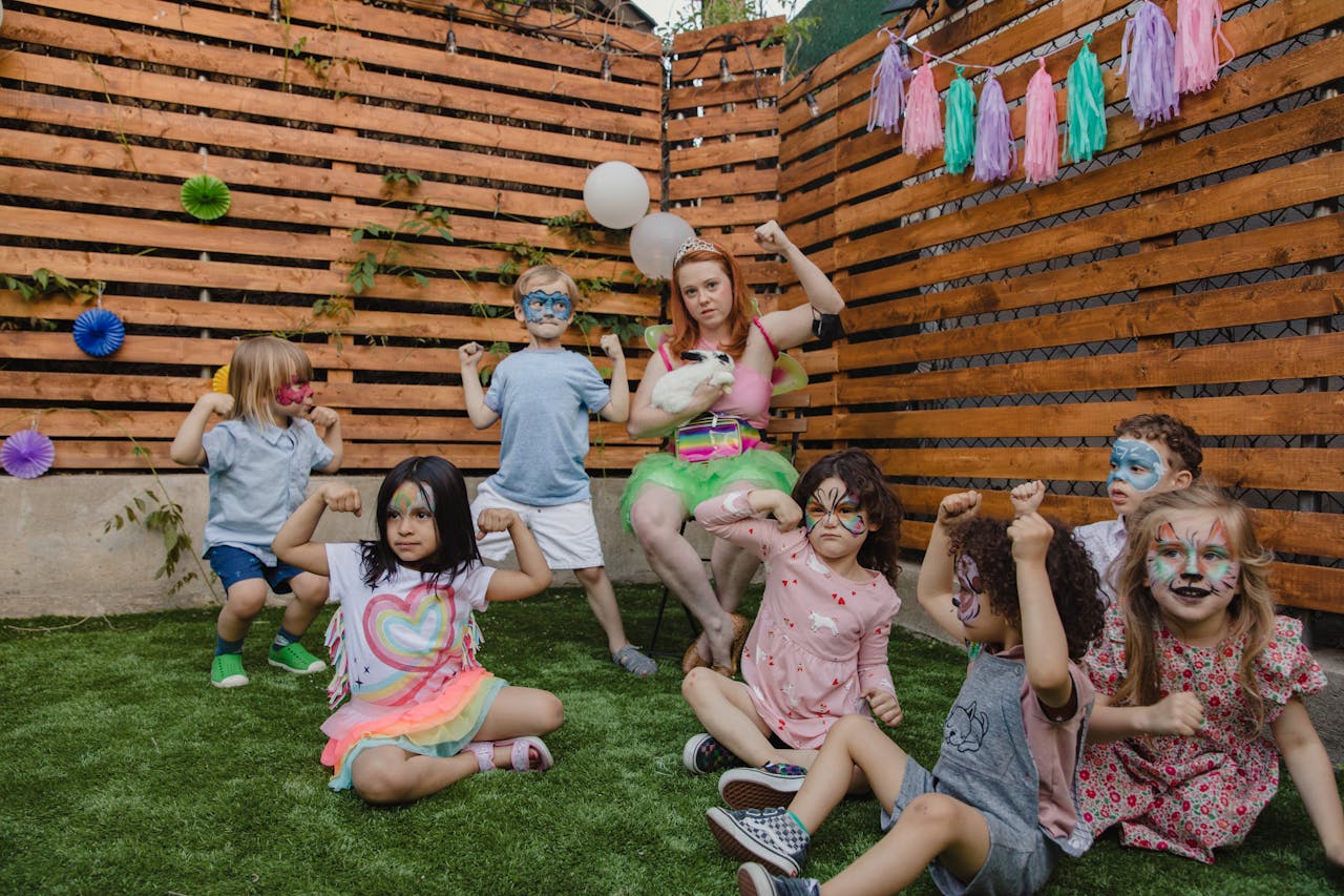 Children enjoying an outdoor party with face painting, costumes, and fun activities.